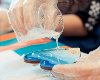 Crafternoon event; person pouring UV resin into a painted heart.